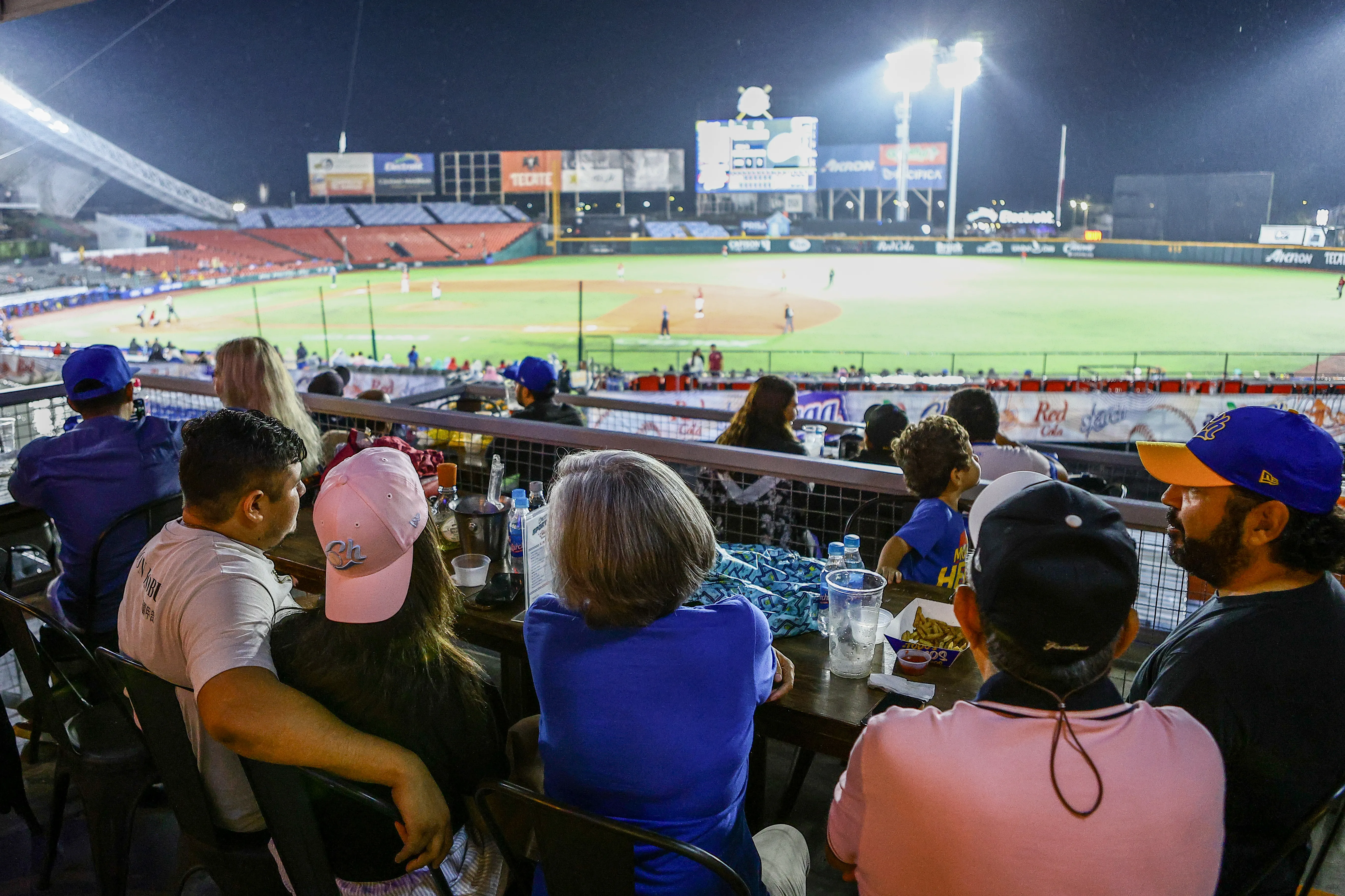 Fans disfrutando del béisbol en Charros Sport Bar